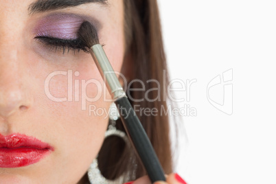 Woman getting applied red lips and smoky eyes