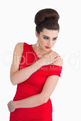 Woman in red dress holding her shoulder