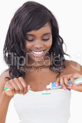 Woman putting toothpaste on brush