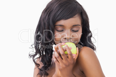 Woman holding an apple with eyes closed