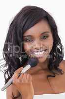 Woman holding makeup brush to face