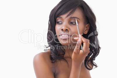 Woman holding eye shadow brush to eyes