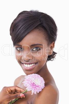 Woman smiling and holding a pink coloured flower