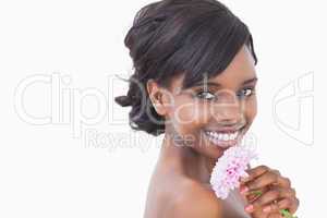 Pretty woman smiling while holding a pink coloured flower