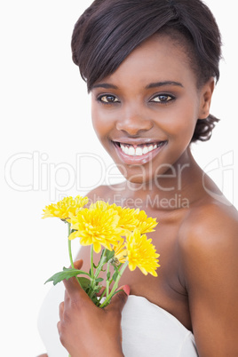 Woman smiling holding yellow flowers