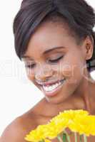 Woman smiling while holding yellow flowers