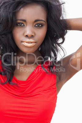 Woman standing hands on neck wearing red dress