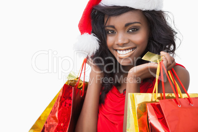 Festive woman standing looking while holding bags