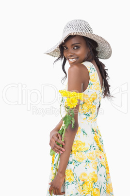 Woman standing holding yellow flowers