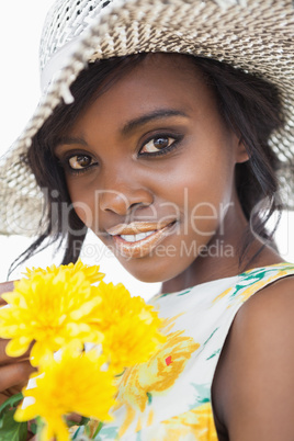 Woman wearing hat and holding flowers