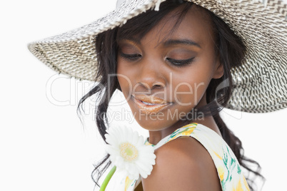 Woman wearing summer hat and holding white flower