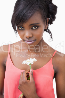 Woman holding daisy wearing pink dress