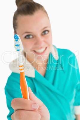 Woman with bathrobe showing her toothbrush