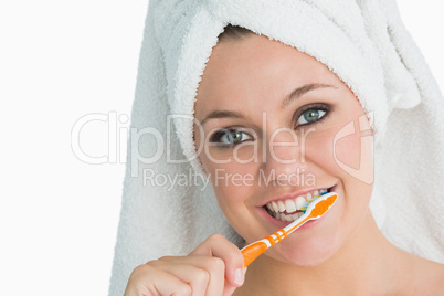 Woman with hair towel washing her teeth