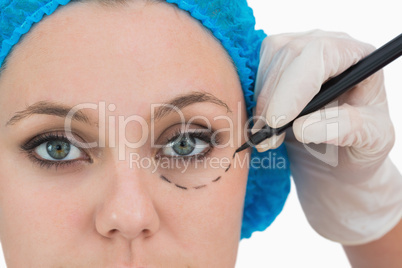 Plastic surgeon writing on the serious woman's face