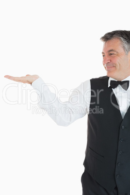 Smiling waiter holding something