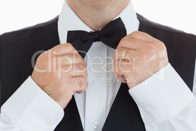 Man adjusting his bow tie