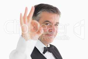 Well-dressed waiter making ok sign