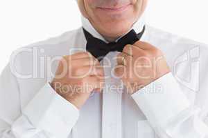 Smiling man fixing bow tie