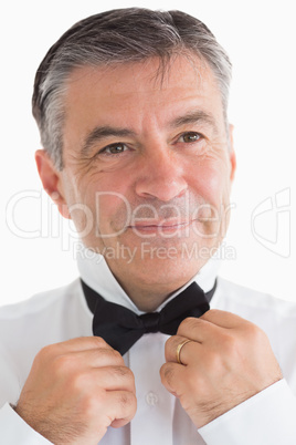 Happy man adjusting his bow tie