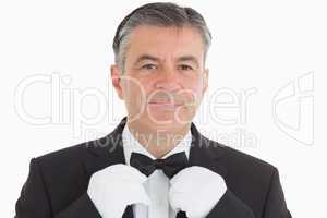 Smiling waiter adjusting his bow tie