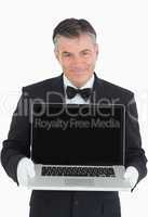 Smiling waiter showing us something on a laptop
