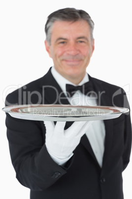 Smiling waiter holding a silver tray