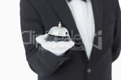 Well-dressed man holding a hotel bell