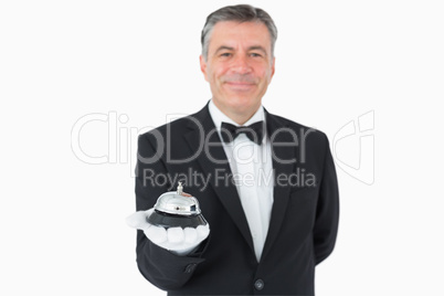Man in suit holding hotel bell