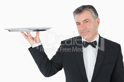 Well-dressed waiter holding a silver tray