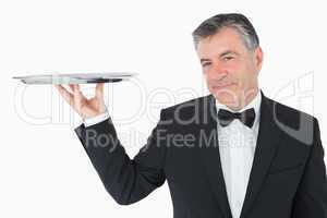 Well-dressed waiter holding a silver tray