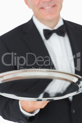 Waiter smiling and holding a silver tray