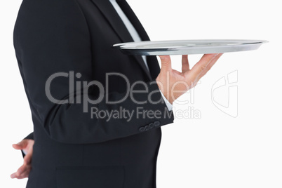 Waiter standing and holding a silver tray