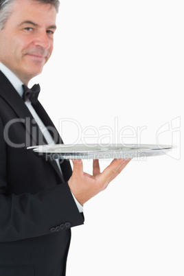 Waiter holding a silver tray with his hand