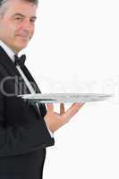 Waiter holding a silver tray with his hand