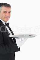 Waiter looking at camera while holding a silver tray