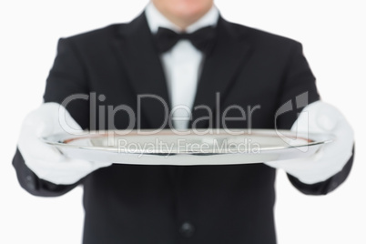 Waiter holding a silver tray with both hands