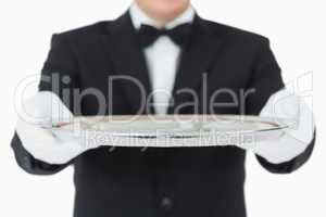 Waiter holding a silver tray with both hands