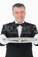 Waiter looking at the camera while holding a silver tray