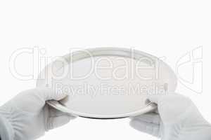 Gloved hands holding silver tray