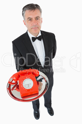 Waiter holding a red dial phone