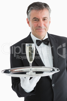 Smiling man serving champagne on tray