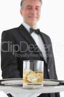 Man holding glass of whiskey on tray