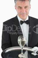 Waiter serving glass of wine on tray