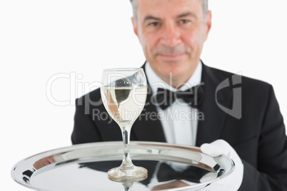 Smiling man serving glass of wine on platter