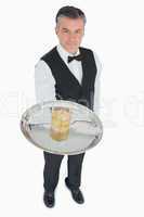 Waiter serving whiskey on silver tray