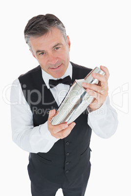 Waiter shaking drink in cocktail shaker