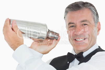 Happy waiter shaking drink in cocktail shaker