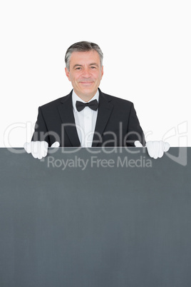 Waiter standing behind grey sign