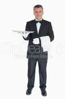 Smiling waiter holding out tray